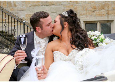 A bride and groom sharing a kiss in their wedding car