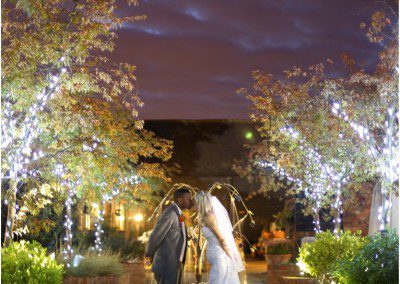 A bride and groom sharing a kiss by the fountain at the barnyard, upchurch